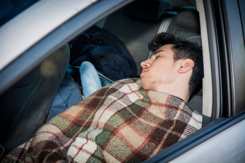 Young handosme man sleeping in his car