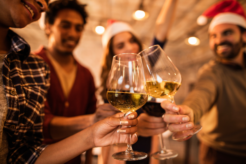 Close up of group of business people toasting with wine during a Christmas party. Focus is on foreground.