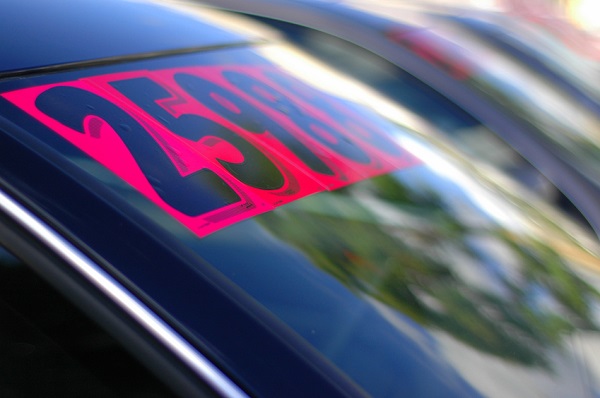 "Retail Business Image of Price Stickers on a Row of Used Cars, With Shallow Depth of Focus"