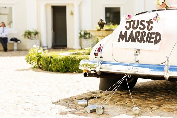 Just married sign and cans attached to convertible car. Horizontal shot.